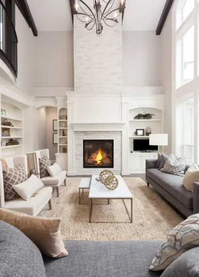 Elegant clean living room with a tall white brick fireplace and furniture